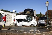 Потоки воды увлекали за собой сотни автомобилей. // AFP